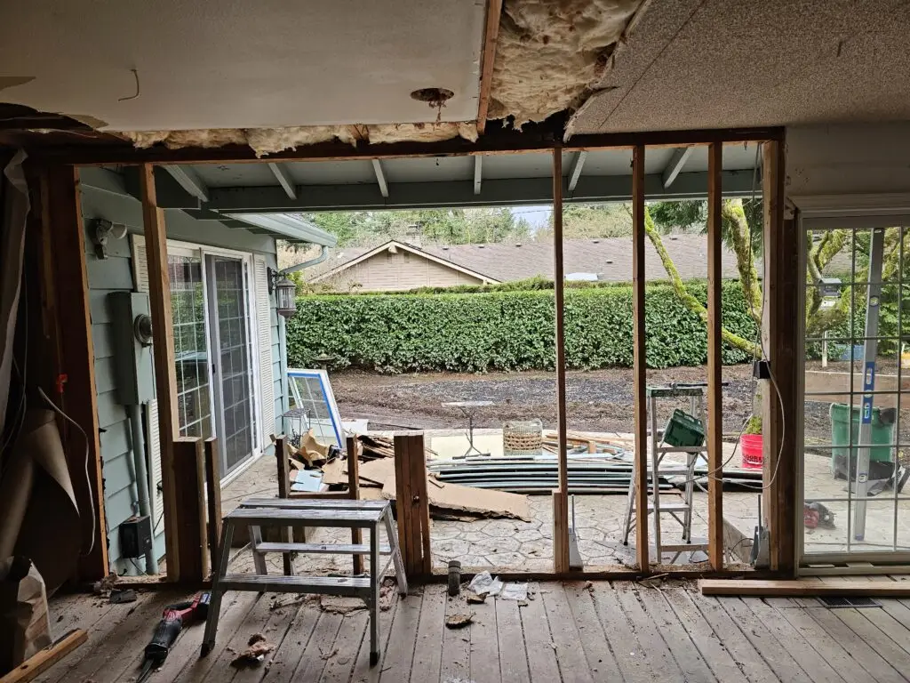 Exposed wall studs and structural framing during a dry rot repair