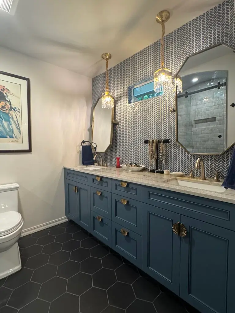 Blue double vanity with stone top, mosaic backsplash and framed mirrors
