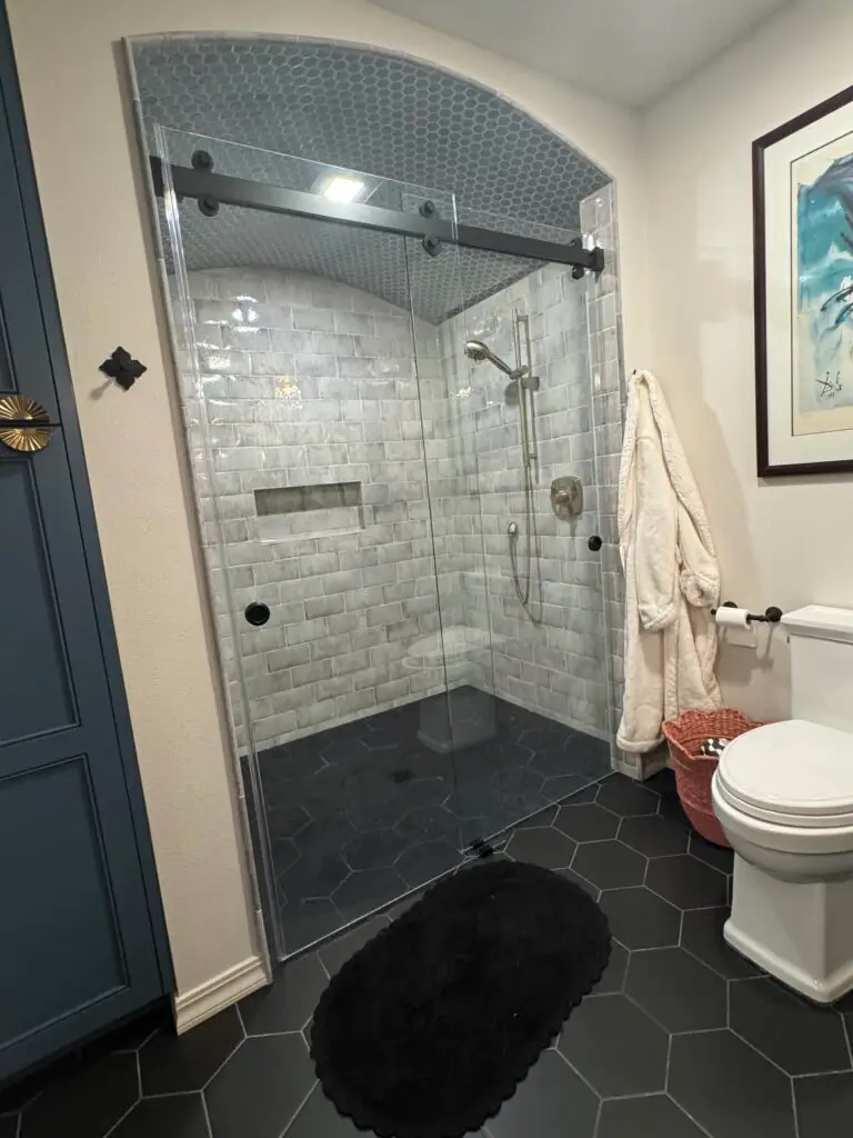 Large-format tile shower and floor in a remodeled bathroom